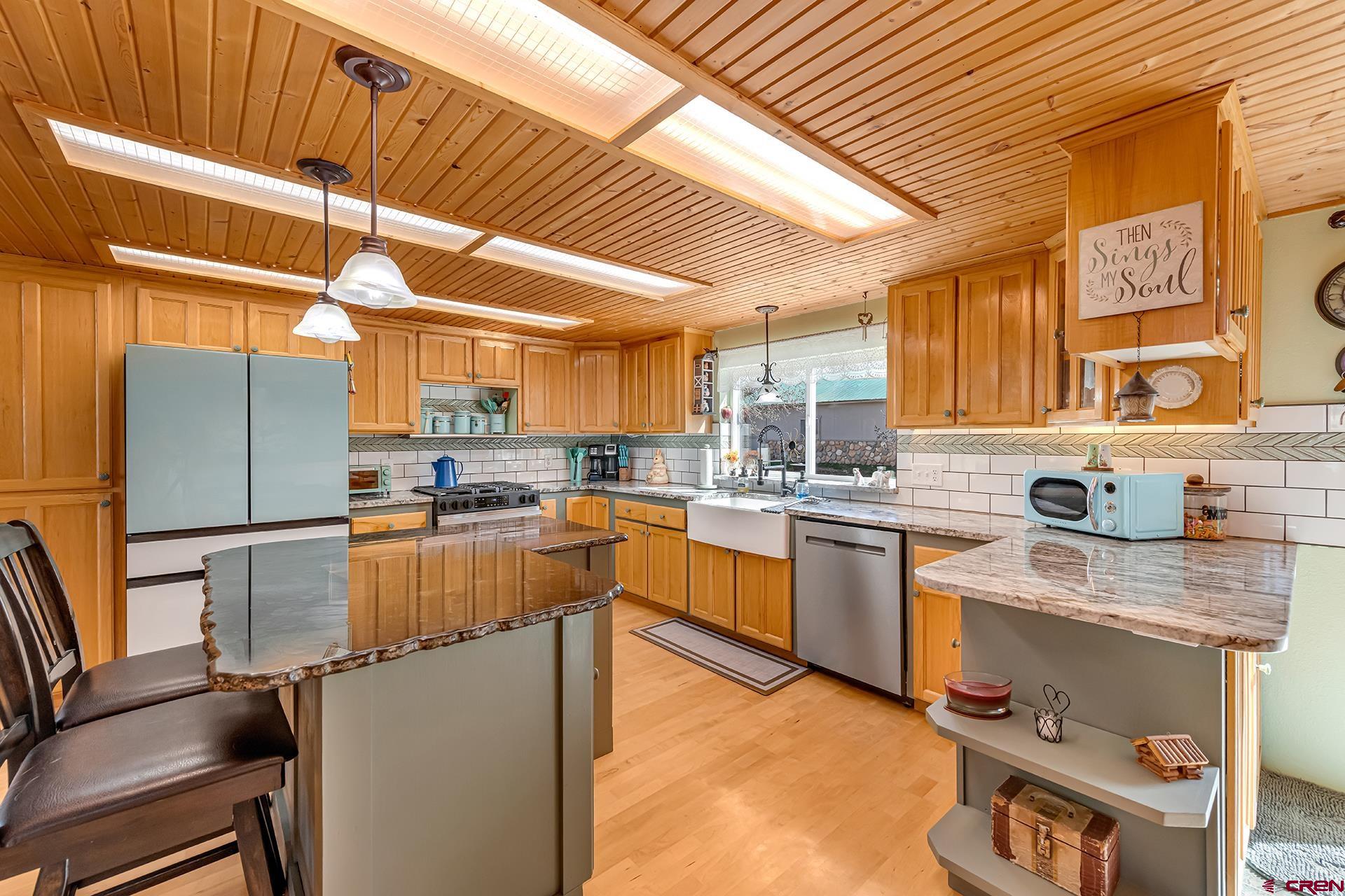 19122 2325th Road Cedaredge, CO 81413 - Photo 10 of 45 a kitchen with stainless steel appliances granite countertop a sink a stove and a refrigerator