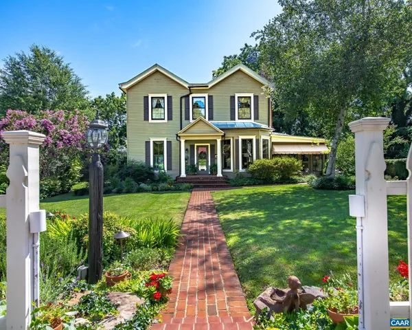 a front view of a house with a yard and potted plants