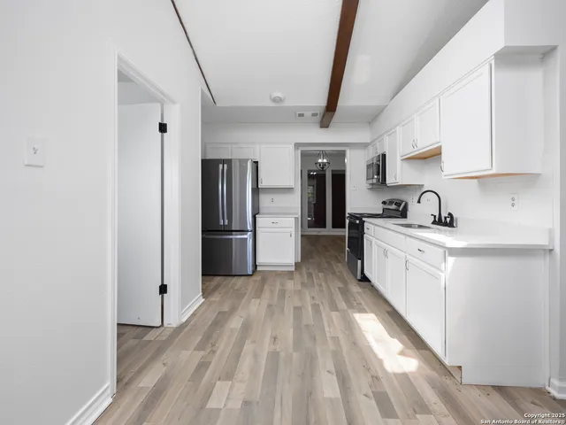 a kitchen with white cabinets and stainless steel appliances