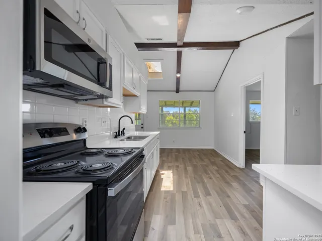 a kitchen with stainless steel appliances a sink stove and cabinets