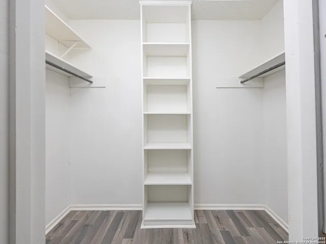 a view of walk in closet with empty racks