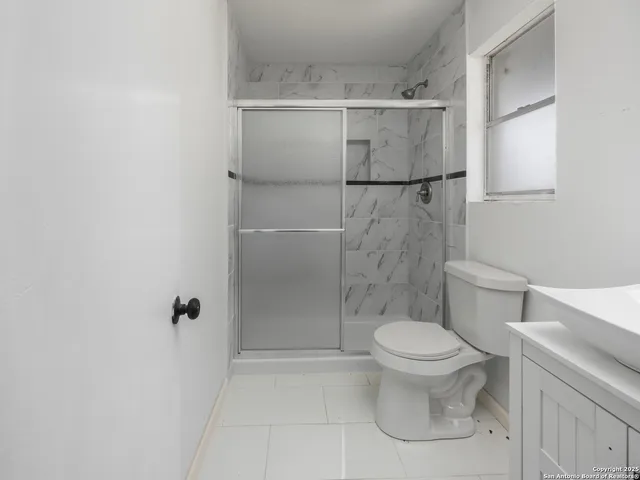a bathroom with a toilet and a shower