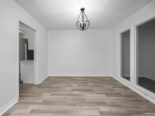 a view of a room with wooden floor and white walls