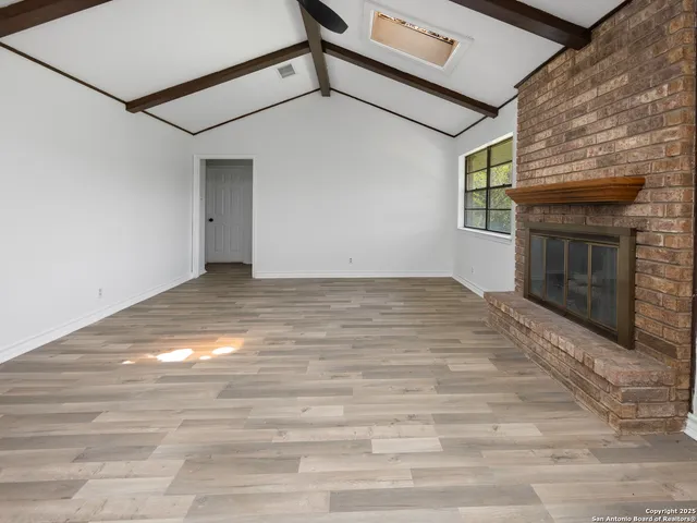 a view of a livingroom with wooden floor and a fireplace