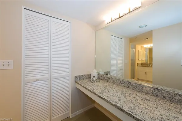 a bathroom with a granite countertop sink and a mirror