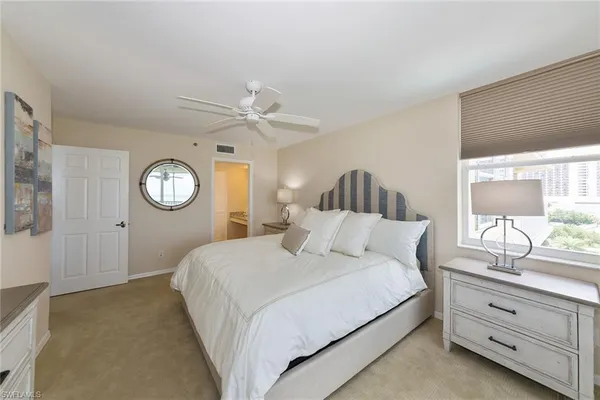 a bedroom with a large bed and a large mirror