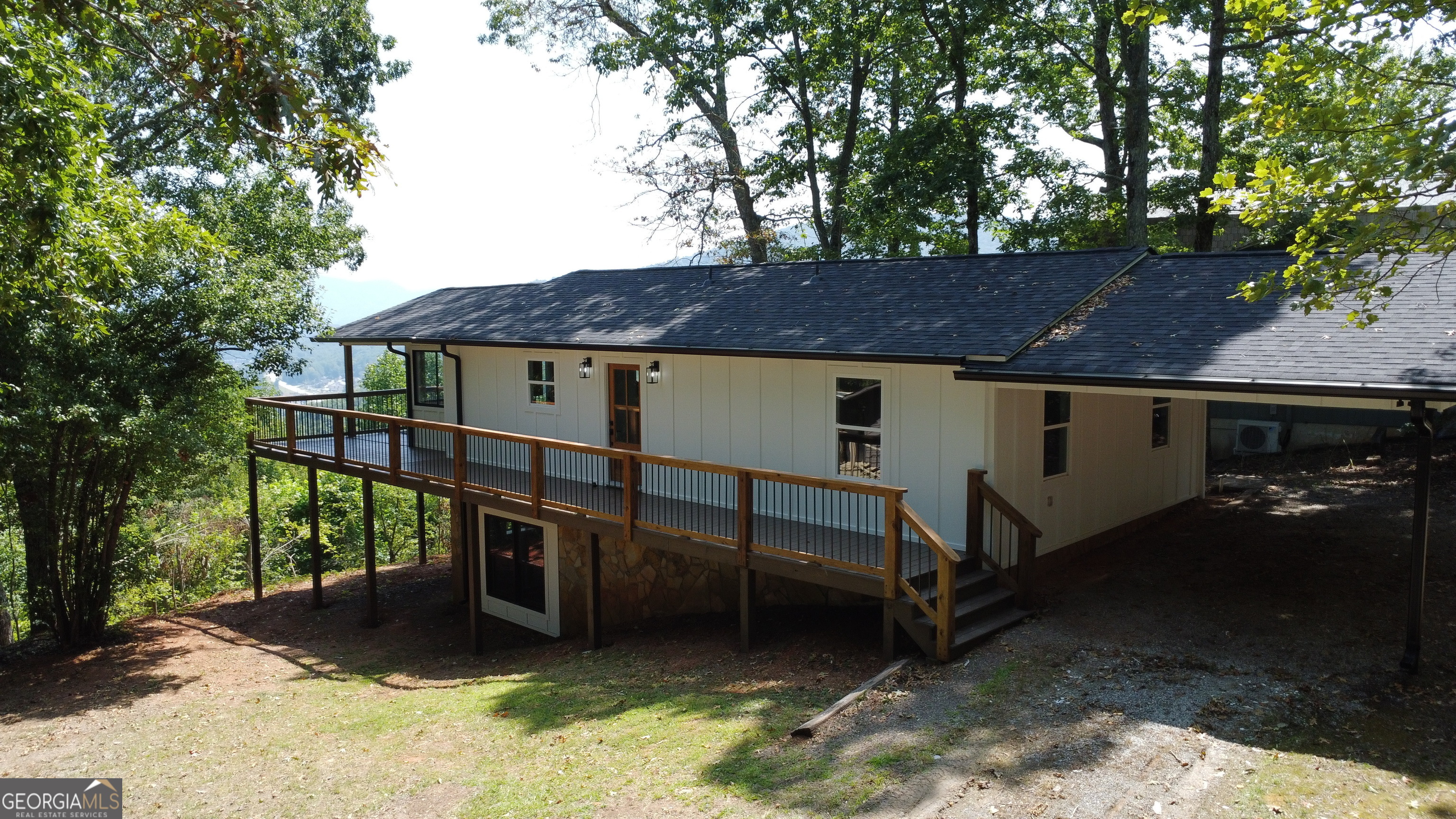 a view of house with outdoor seating area and trees around