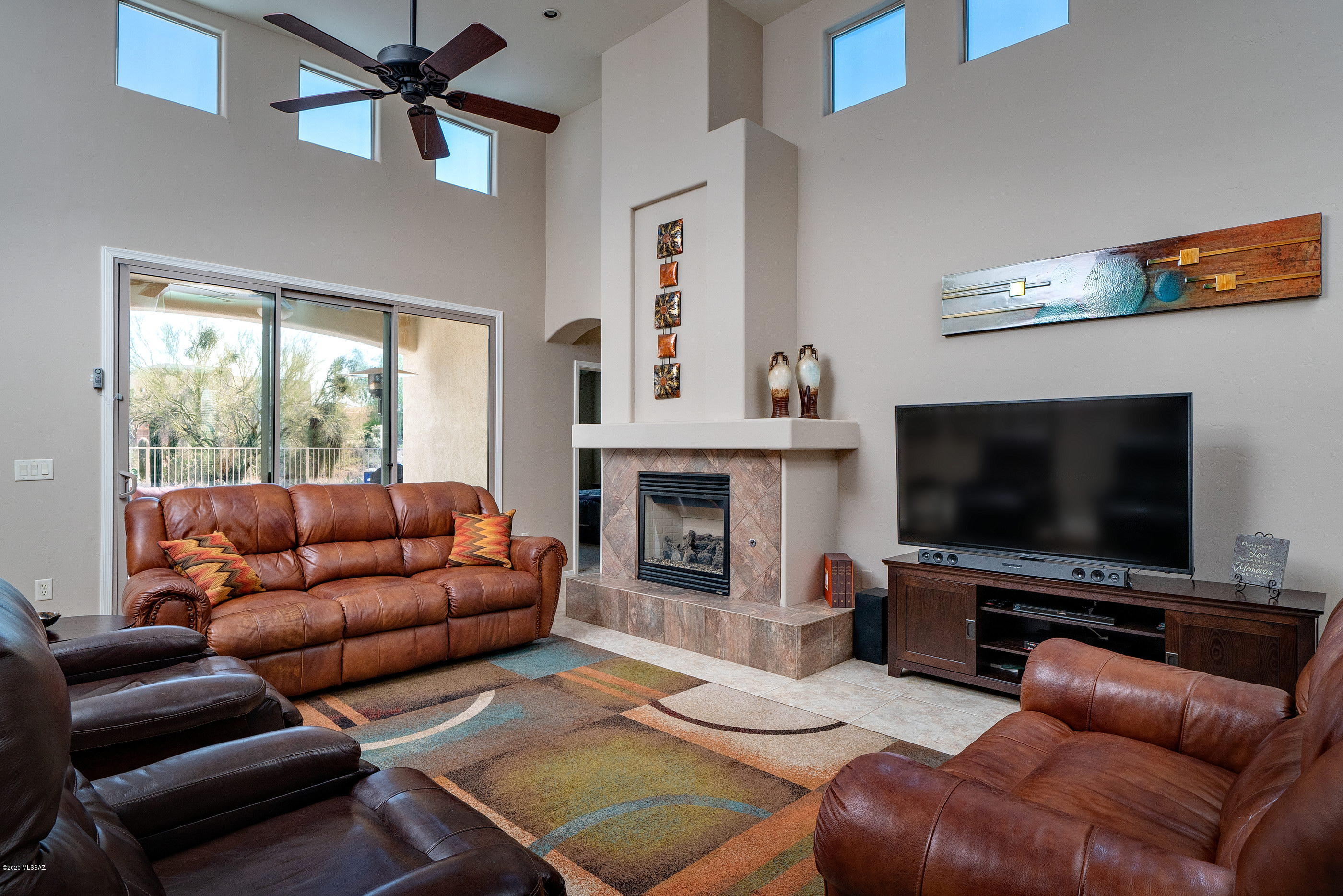 4440 West Crystal Ranch Place Marana, AZ 85658 - Photo 9 of 28 a living room with furniture a flat screen tv and a fireplace
