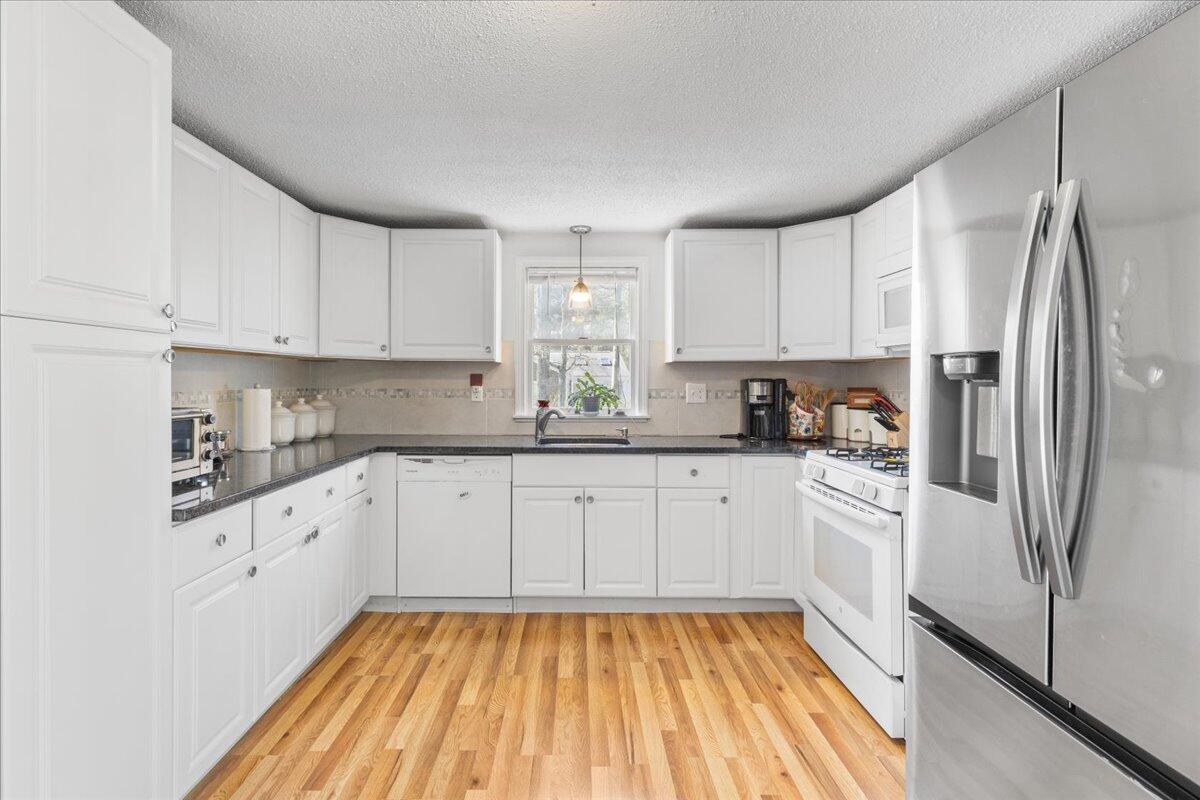 66 Barker Road Wareham, MA 02538 - Photo 11 of 18 a kitchen with granite countertop a refrigerator sink and white cabinets
