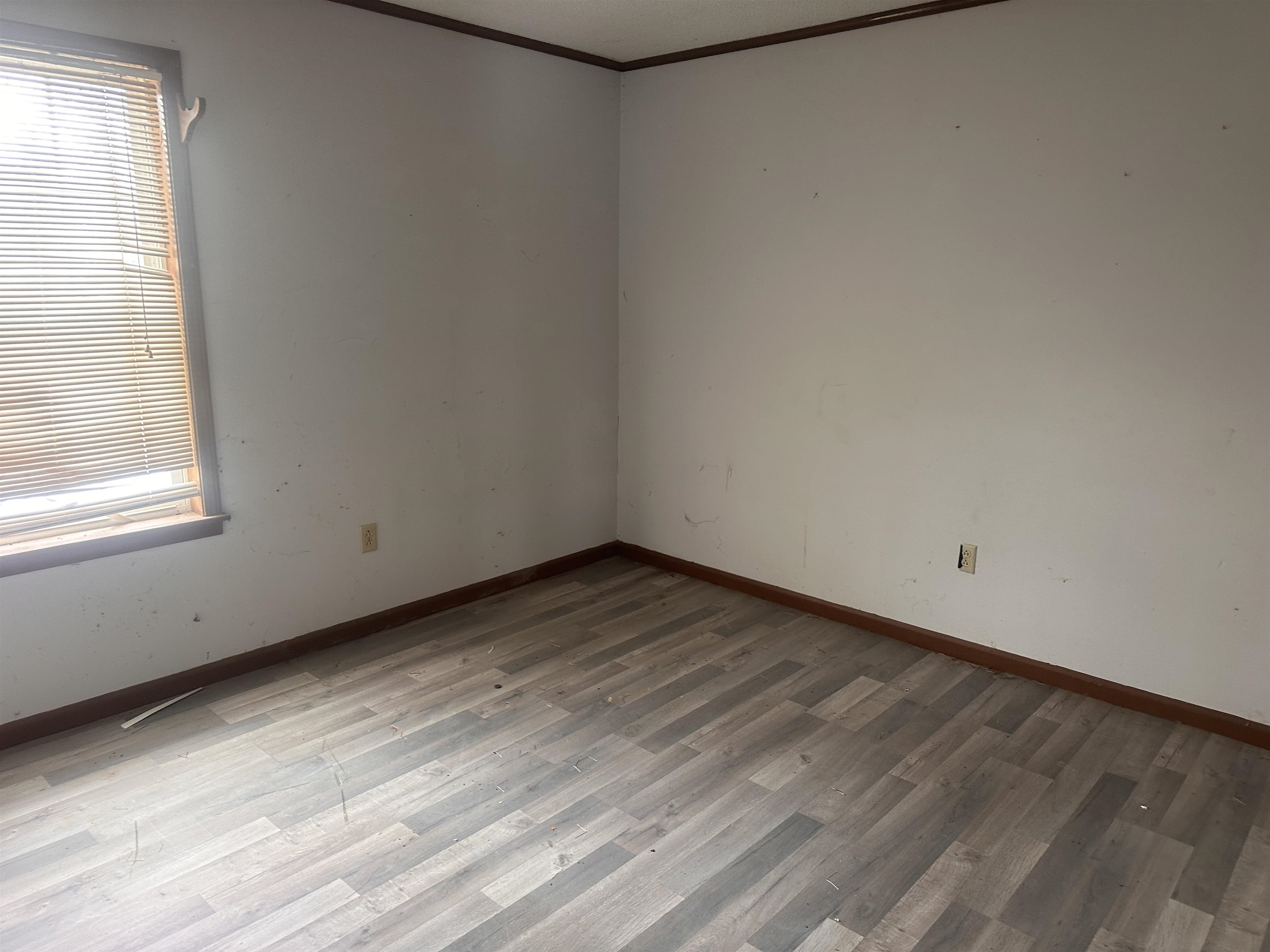 605 Jr Drive Covington, TN 38019 - Photo 15 of 21 Empty room with crown molding and wood finished floors