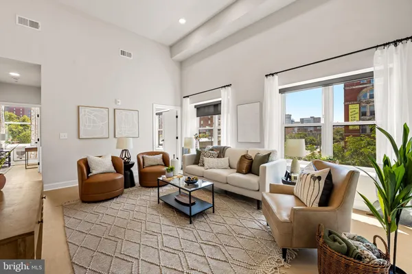 a living room with furniture and floor to ceiling windows