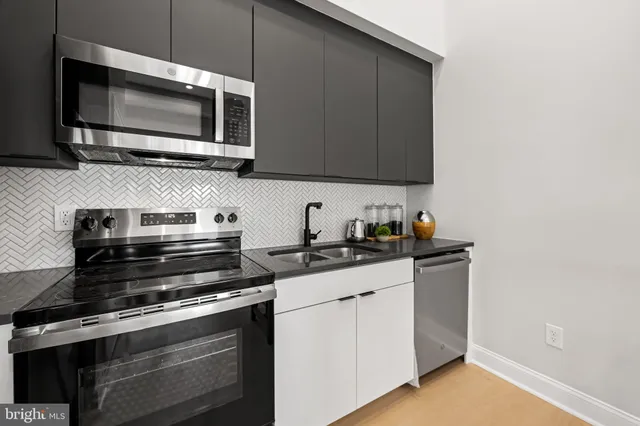 a kitchen with stainless steel appliances a stove a microwave sink and cabinets
