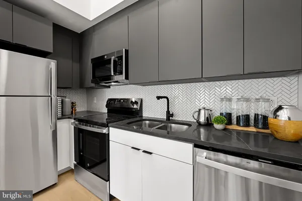 a kitchen with stainless steel appliances granite countertop a refrigerator a sink a stove a microwave and cabinets