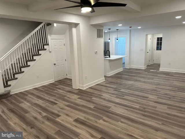 a view of a hallway with wooden floor and staircase