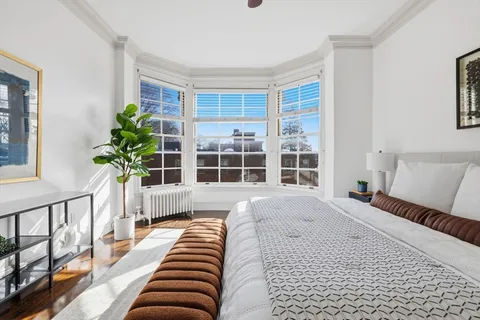 a bedroom with furniture and a large window