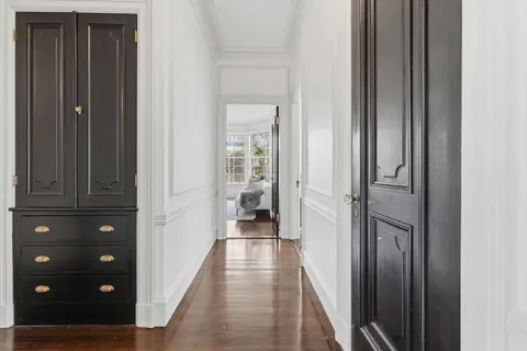 a view of a hallway with closet and wooden floor