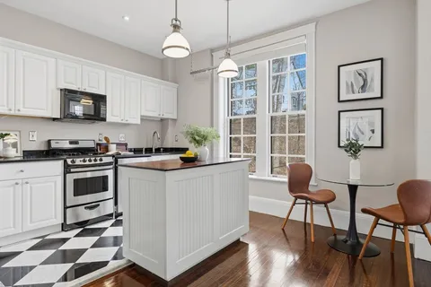 a kitchen with stainless steel appliances a stove a sink a microwave a refrigerator and cabinets