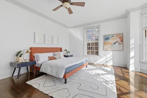 a bedroom with a bed and wooden floor