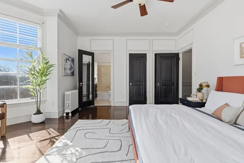 a bedroom with a large bed and a potted plant