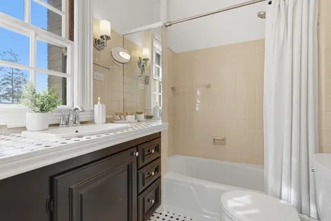 a bathroom with a granite countertop sink a toilet and shower