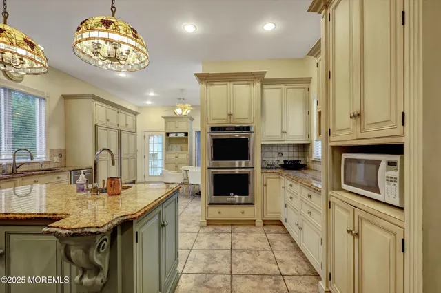 a kitchen with sink a refrigerator and chairs