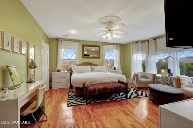 a bedroom with natural light and wooden floor