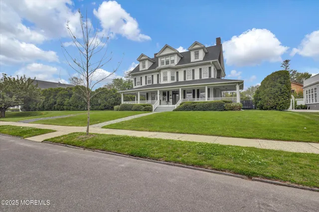 a view of a house with a big yard and large trees