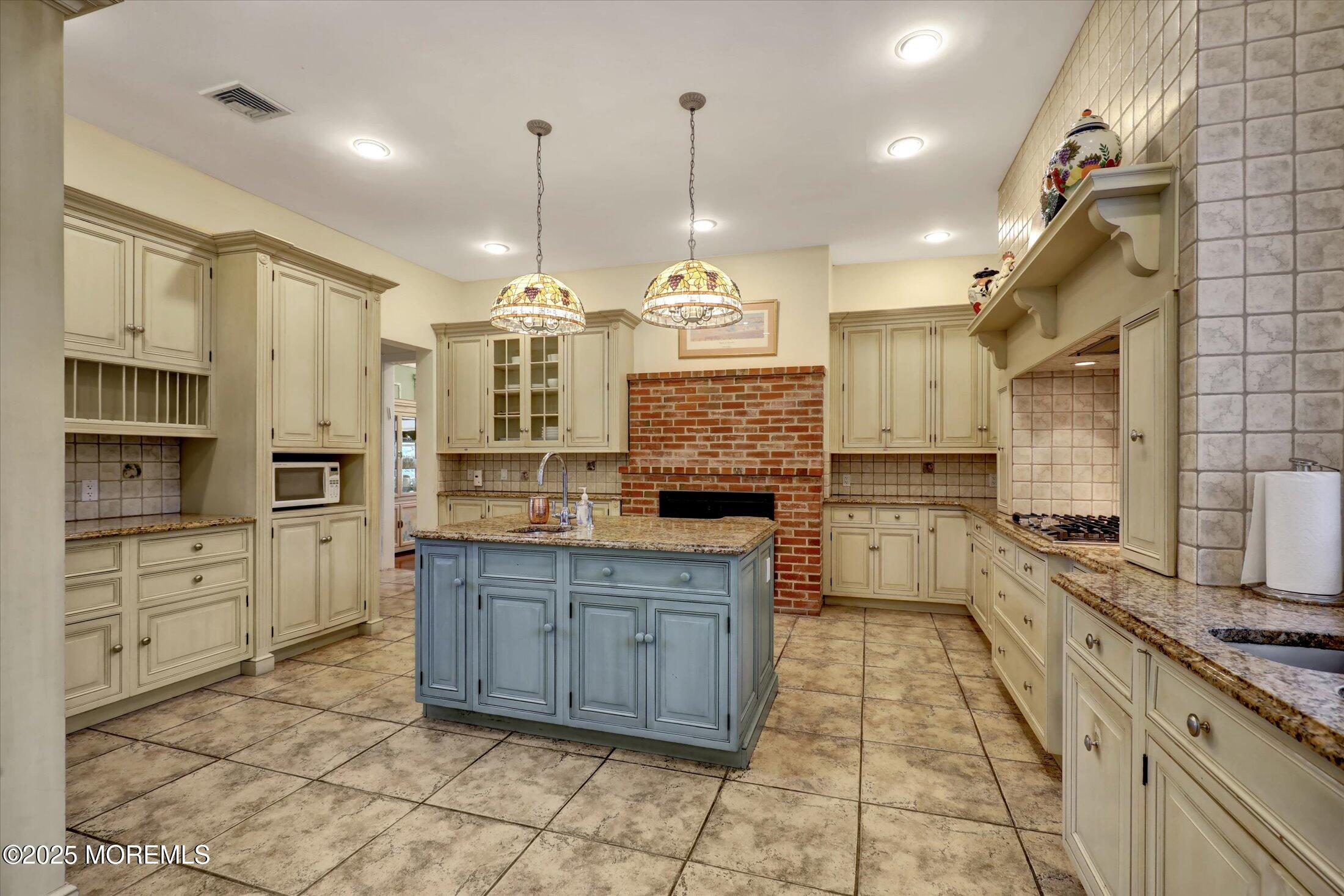 48 Neptune Avenue Deal, NJ 07723 - Photo 37 of 64 a large kitchen with stainless steel appliances kitchen island granite countertop a stove a sink a refrigerator and a wooden cabinets