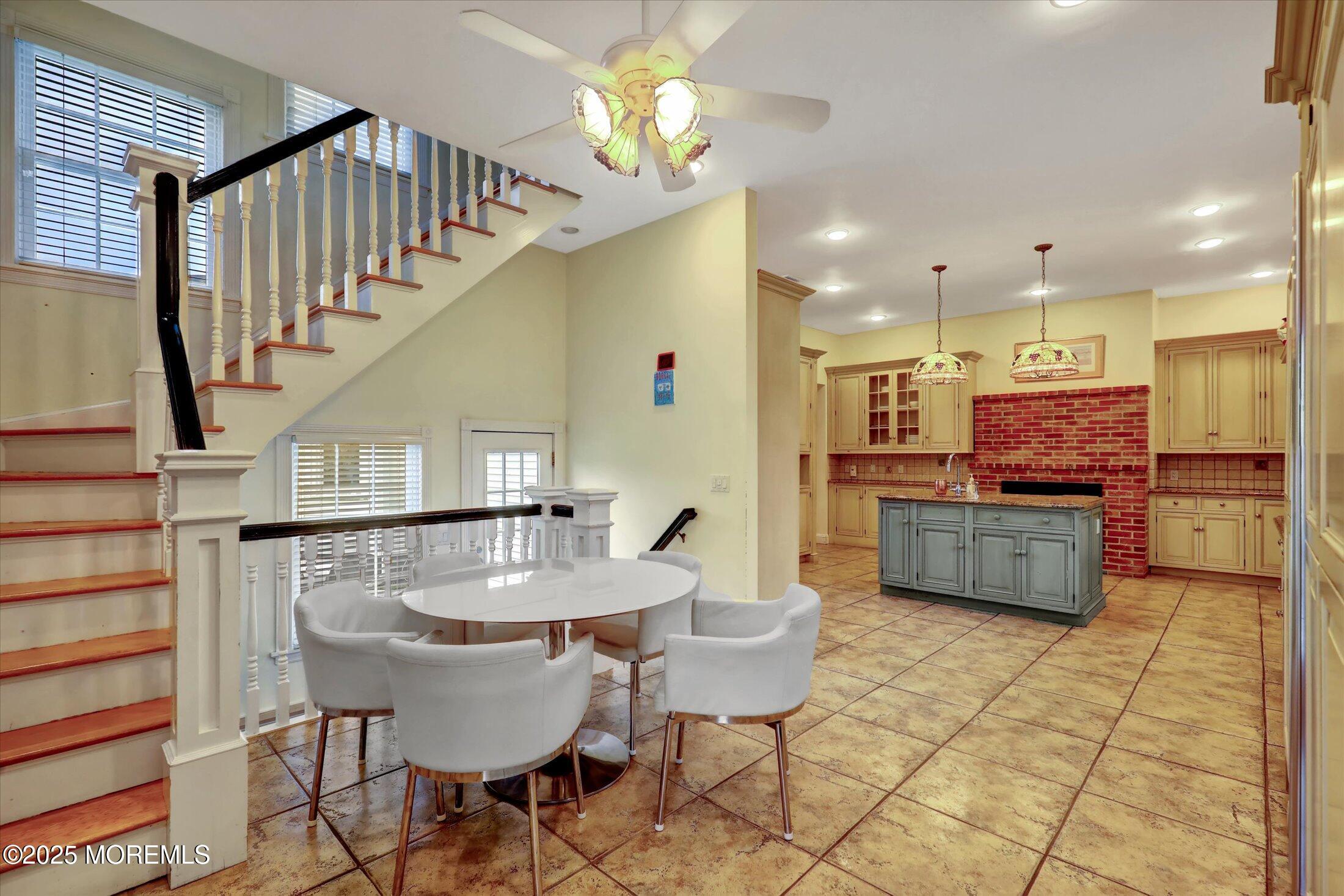 48 Neptune Avenue Deal, NJ 07723 - Photo 39 of 64 a kitchen with stainless steel appliances kitchen island granite countertop a table chairs and a refrigerator