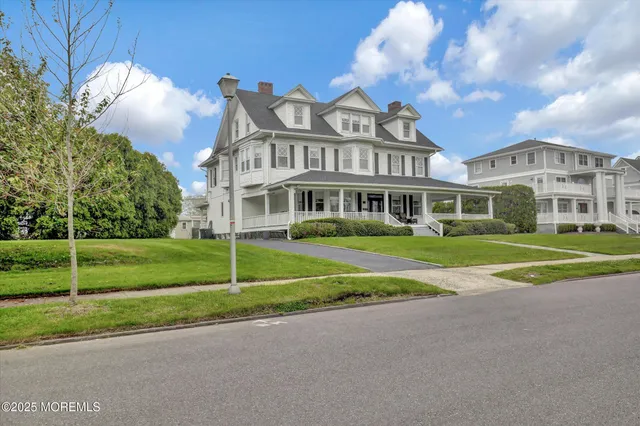 a view of a big house with a big yard and large trees