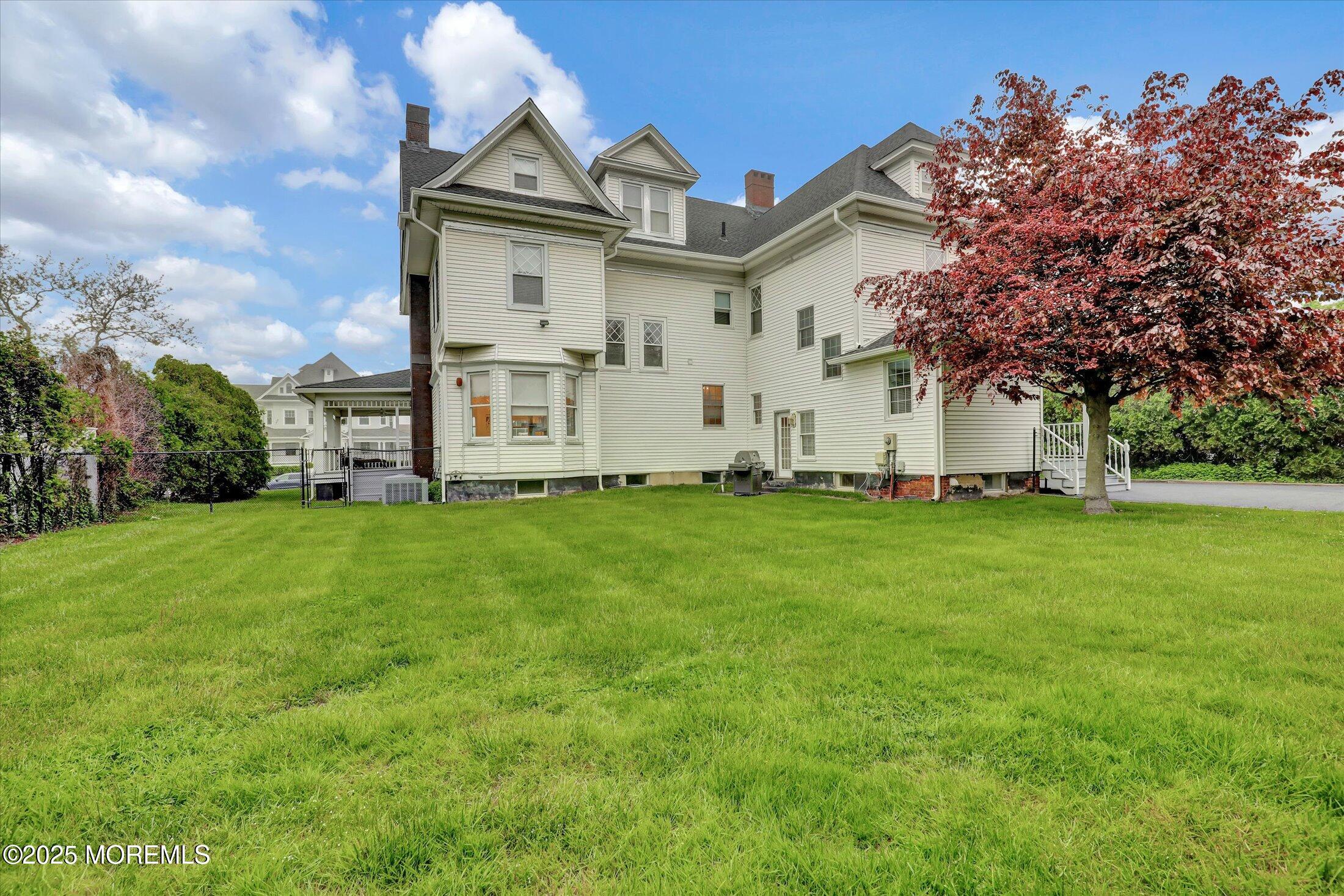 48 Neptune Avenue Deal, NJ 07723 - Photo 48 of 64 a view of a white house with a big yard and large trees