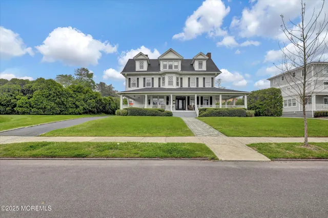 a view of a big house with a big yard and large trees