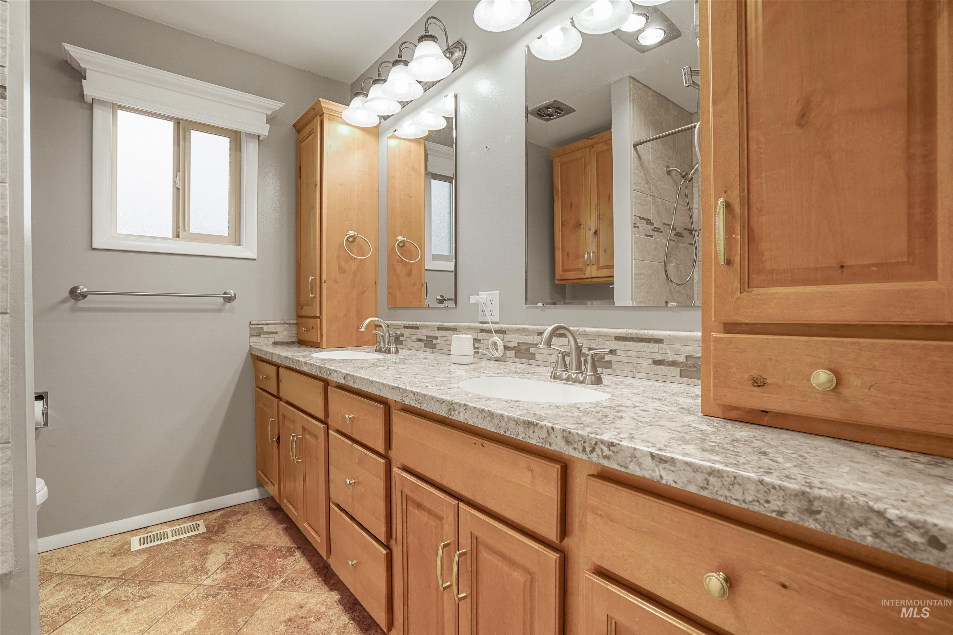 206 Pleasant Way Rupert, ID 83350 - Photo 19 of 33 Bathroom with double vanity, a tile shower, and light tile patterned floors