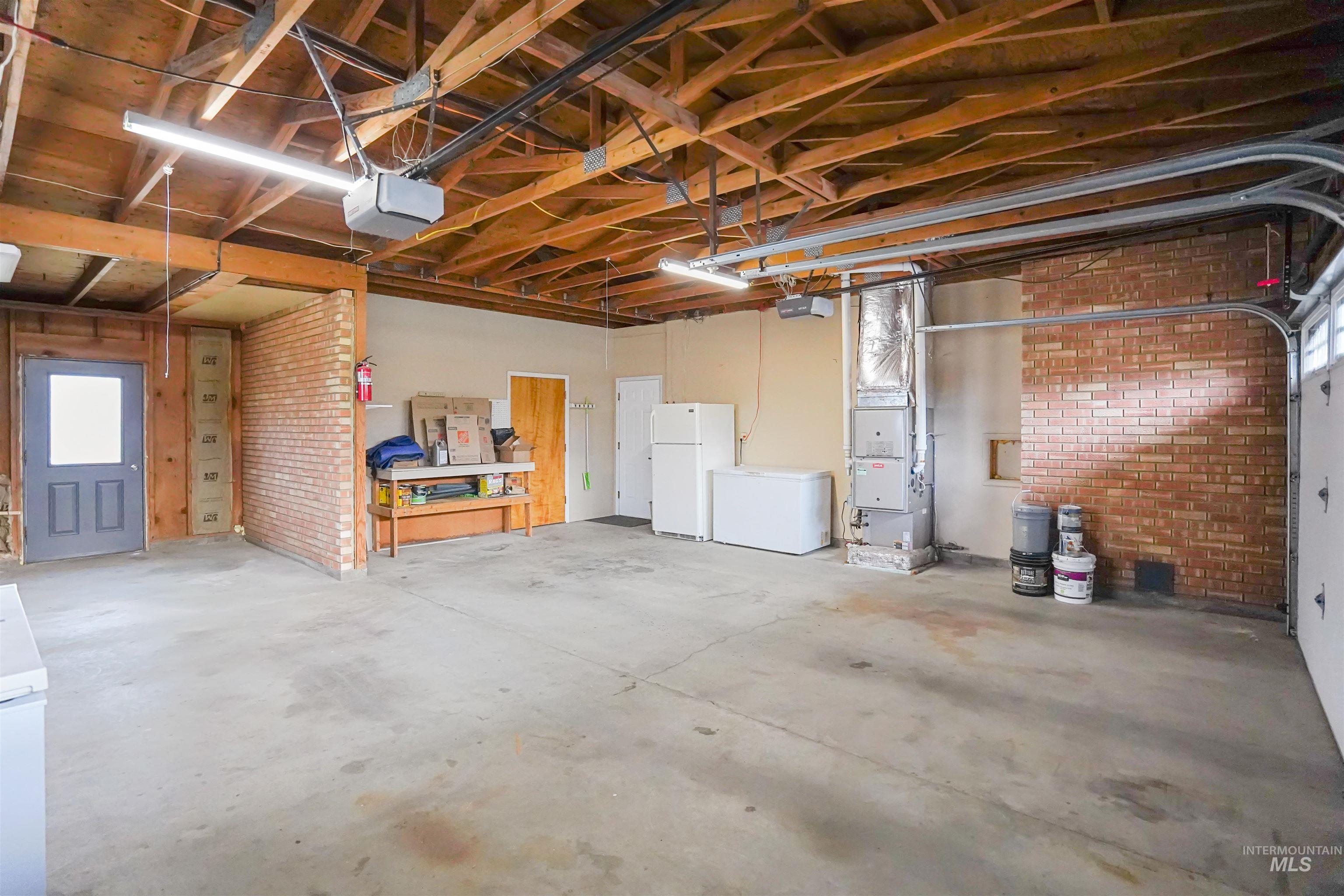 206 Pleasant Way Rupert, ID 83350 - Photo 28 of 33 Garage with freestanding refrigerator, heating unit, and a garage door opener