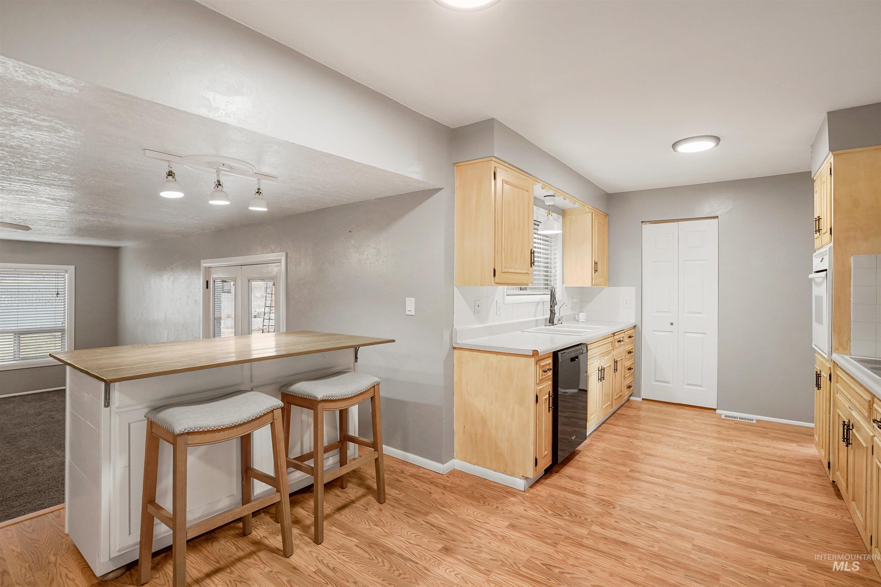 206 Pleasant Way Rupert, ID 83350 - Photo 9 of 33 Kitchen featuring light wood finish cabinetry, a kitchen bar, light wood finished floors, and butcher block countertops