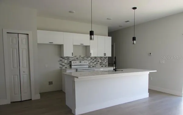 a kitchen with kitchen island a sink stainless steel appliances and cabinets