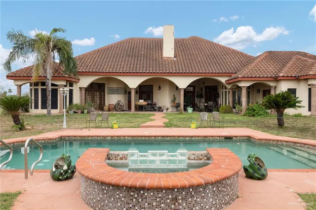a view of a house with swimming pool and a yard