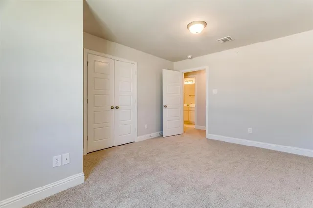 an empty room with closet and mirror