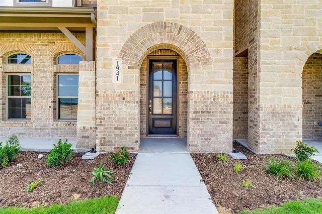 a view of front door of a house with plants and entryway