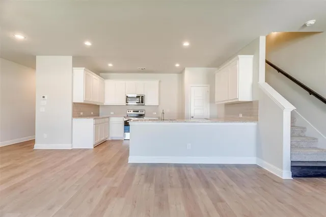 a view of kitchen with wooden floor and electronic appliances