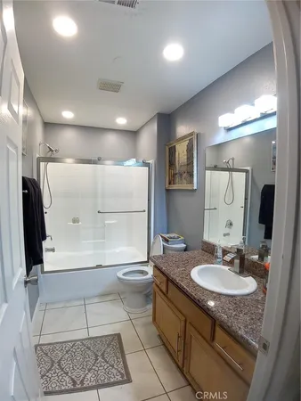 a bathroom with a granite countertop sink a mirror and a shower