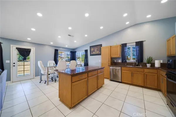 a kitchen with stainless steel appliances granite countertop a sink and a refrigerator