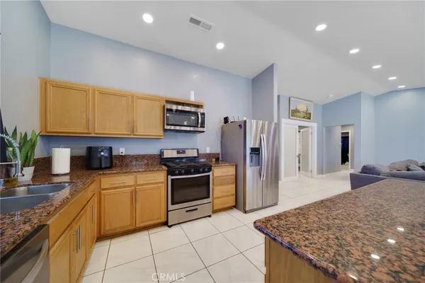 a kitchen with stainless steel appliances granite countertop a sink dishwasher stove top oven and refrigerator