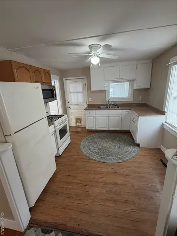 a large kitchen with a sink stainless steel appliances and cabinets
