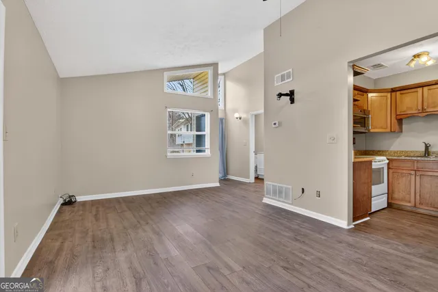 an empty room with wooden floor and windows