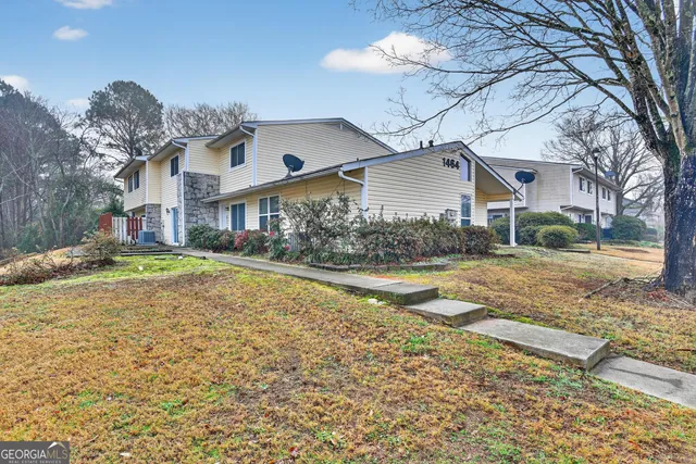 a front view of a house with a yard covered with snow and trees