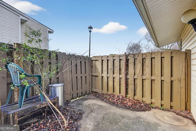 a view of a wooden bench in back yard of a house