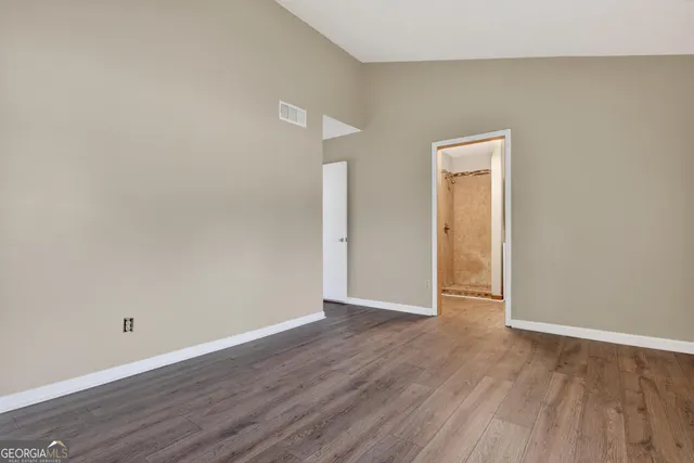 a view of an empty room with wooden floor