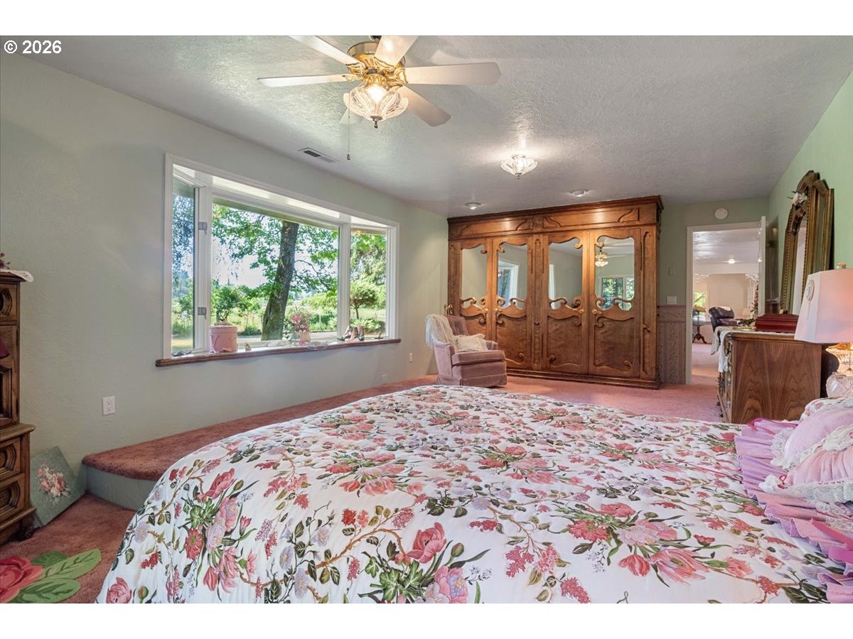 1300 Fair Oaks Road Oakland, OR 97462 - Photo 25 of 48 a bedroom with a large bed and a chandelier