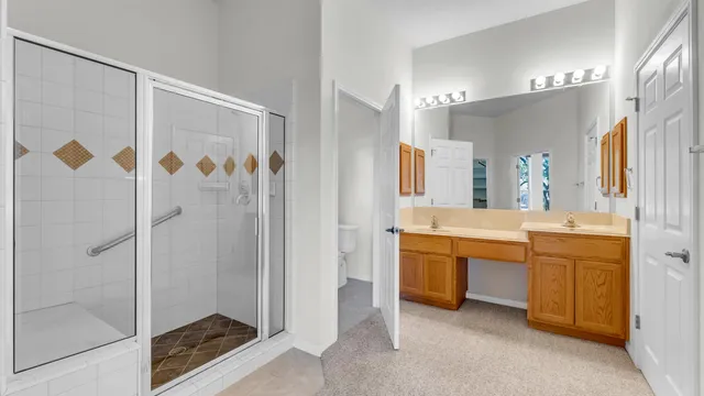 a bathroom with a double vanity sink mirror and shower